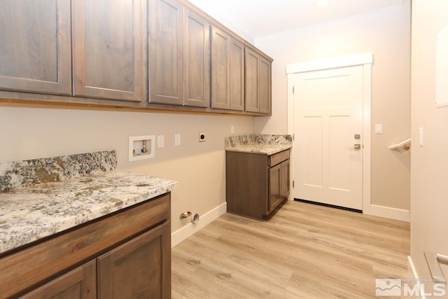 laundry room featuring electric dryer hookup, washer hookup, cabinet space, light wood finished floors, and baseboards