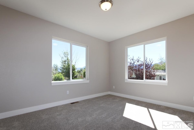 spare room with visible vents, carpet floors, and baseboards