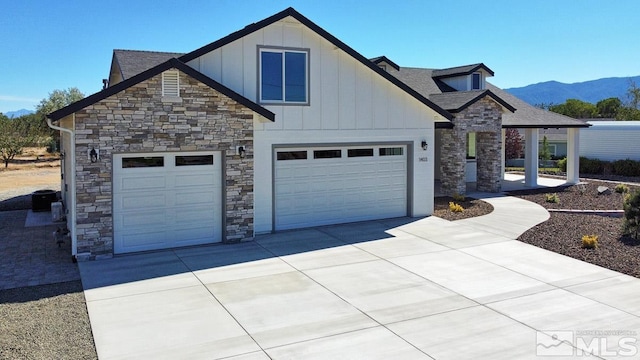 modern farmhouse with stone siding, board and batten siding, and driveway