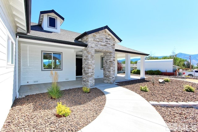 exterior space featuring covered porch, a mountain view, and a shingled roof