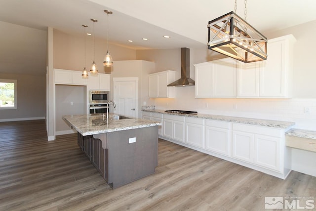 kitchen featuring stainless steel appliances, wall chimney exhaust hood, white cabinets, and light wood-style flooring