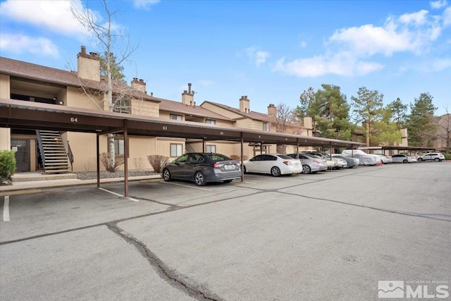 covered parking lot featuring stairway