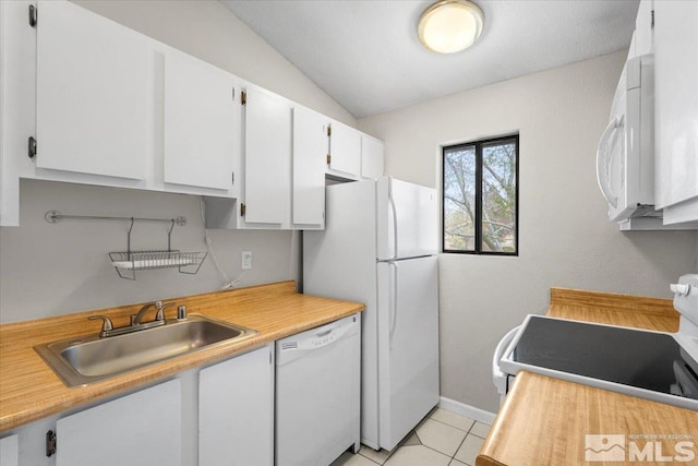 kitchen featuring a sink, white appliances, light tile patterned floors, and light countertops