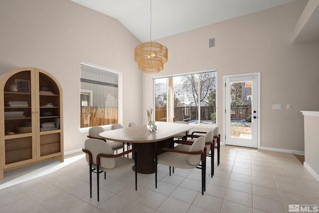 dining area with light tile patterned floors, visible vents, baseboards, and high vaulted ceiling