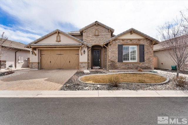 ranch-style home featuring an attached garage, stucco siding, stone siding, a tile roof, and decorative driveway