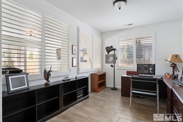 office area featuring light wood finished floors, visible vents, and baseboards