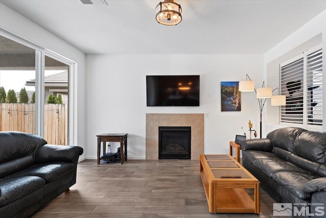 living room featuring a fireplace, wood finished floors, and baseboards