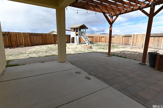 view of patio / terrace featuring a fenced backyard, a pergola, and a playground