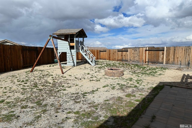 view of play area with a fire pit and a fenced backyard