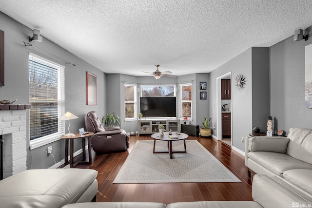 living area with dark wood-style floors, baseboards, a textured ceiling, and a ceiling fan