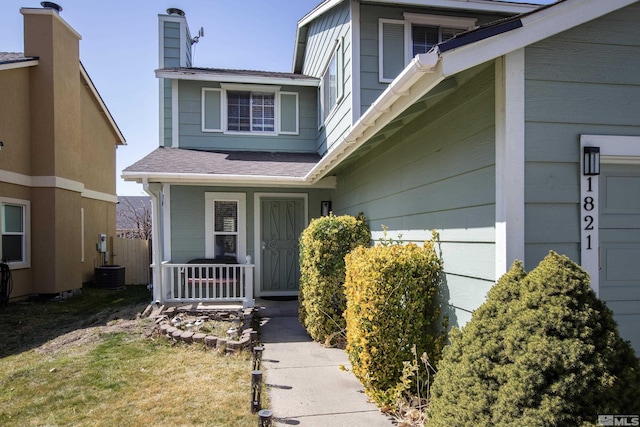 view of exterior entry with central AC unit and covered porch