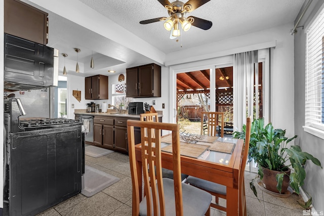 dining room with a raised ceiling, a textured ceiling, and a ceiling fan