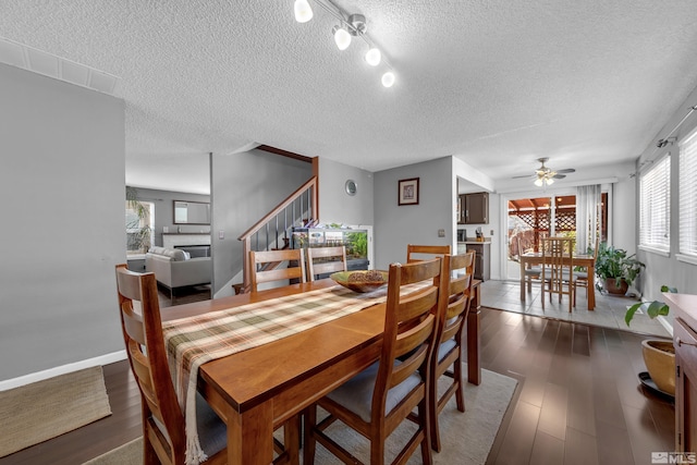 dining area with a textured ceiling, stairs, ceiling fan, and wood finished floors