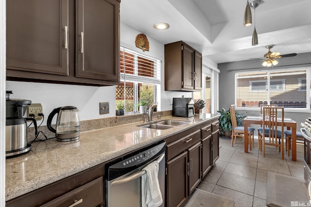 kitchen featuring a sink, dark brown cabinetry, dishwashing machine, light stone countertops, and ceiling fan