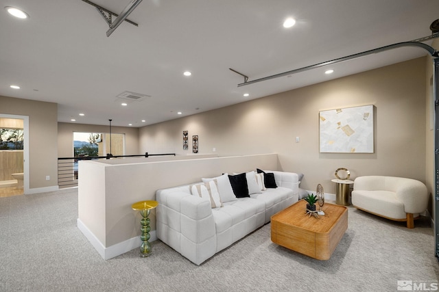 living room with a garage, recessed lighting, visible vents, and light carpet