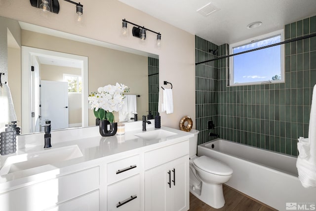 full bathroom featuring bathtub / shower combination, toilet, wood finished floors, and a sink