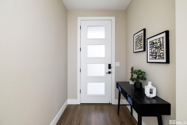 foyer with dark wood-style floors and baseboards