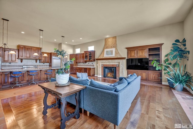 living area with recessed lighting, baseboards, light wood-style floors, and a fireplace