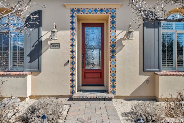 view of exterior entry featuring stucco siding