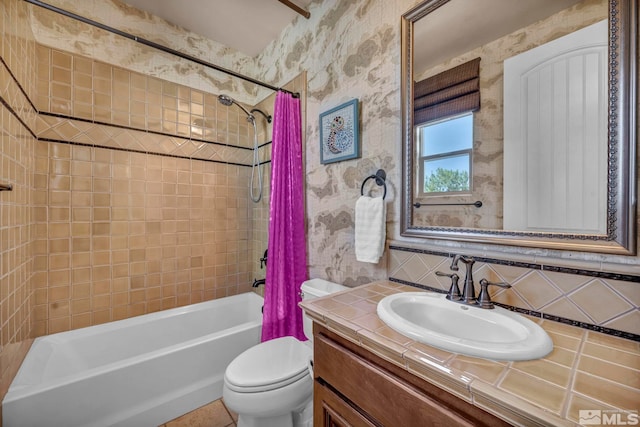 bathroom featuring shower / bath combo with shower curtain, toilet, vanity, and wallpapered walls