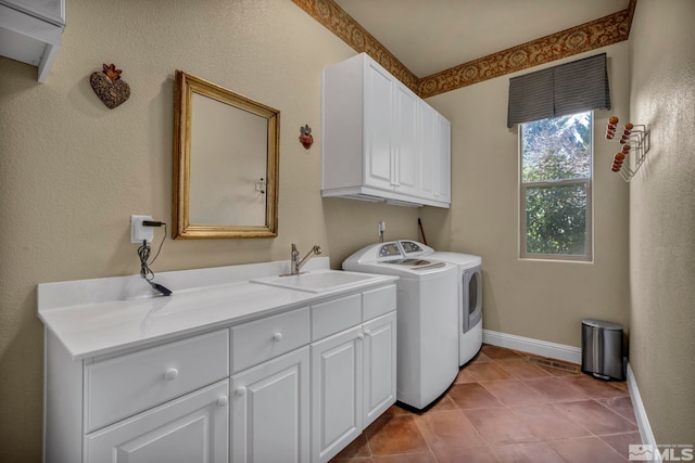 laundry room with baseboards, washing machine and dryer, light tile patterned floors, cabinet space, and a sink