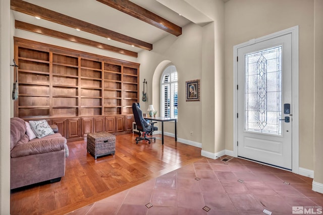 foyer with tile patterned floors, beamed ceiling, baseboards, and a healthy amount of sunlight