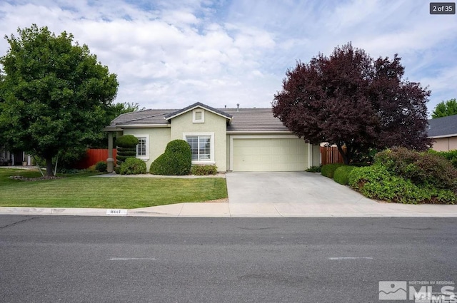 ranch-style house featuring fence, concrete driveway, a front yard, an attached garage, and a tiled roof