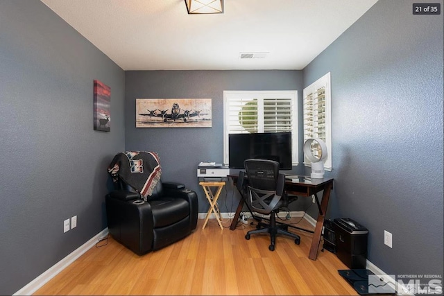 home office featuring wood finished floors, visible vents, and baseboards