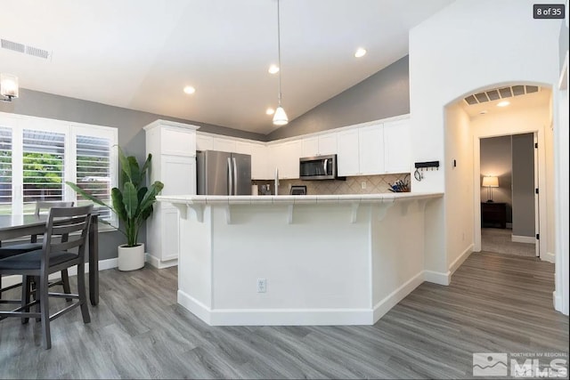 kitchen featuring visible vents, white cabinetry, stainless steel appliances, and decorative backsplash