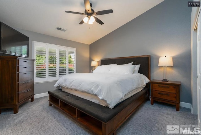 carpeted bedroom with visible vents, baseboards, lofted ceiling, and a ceiling fan