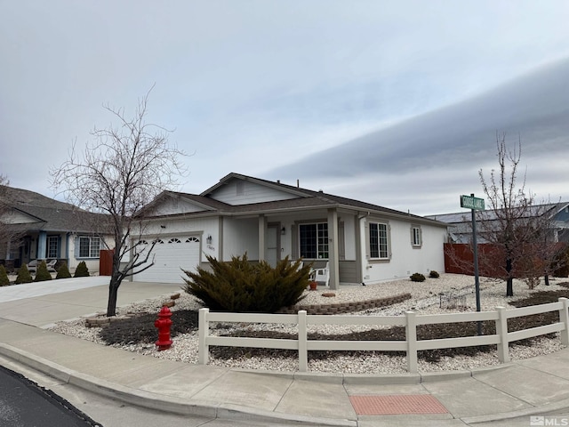 ranch-style home with a fenced front yard, driveway, and a garage