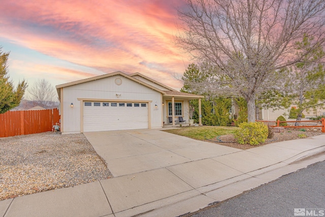 ranch-style house with a garage, driveway, and fence