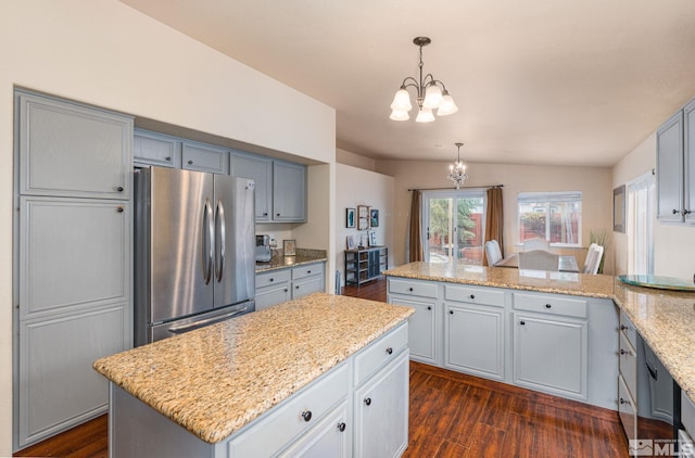 kitchen with a chandelier, dark wood-style floors, a peninsula, and freestanding refrigerator