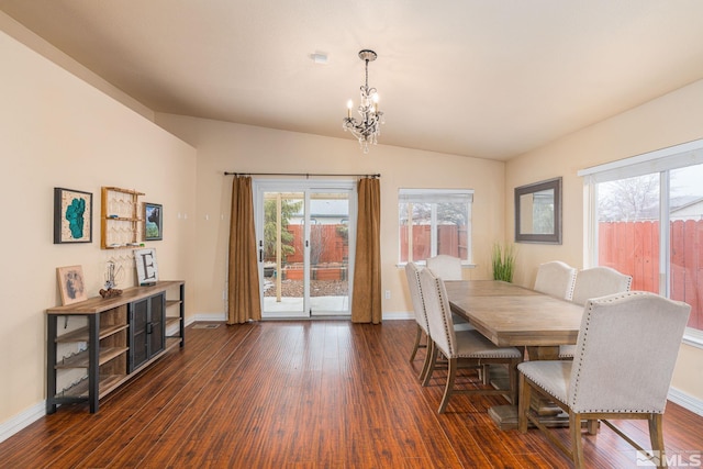 dining room with baseboards, lofted ceiling, an inviting chandelier, and dark wood-style floors