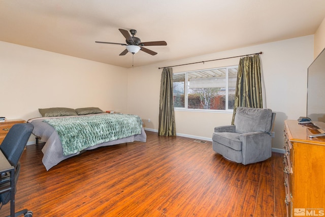 bedroom with a ceiling fan, wood finished floors, visible vents, and baseboards