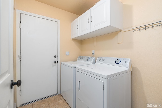 washroom featuring light tile patterned floors, cabinet space, and washer and clothes dryer