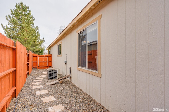 view of side of home with central air condition unit and a fenced backyard