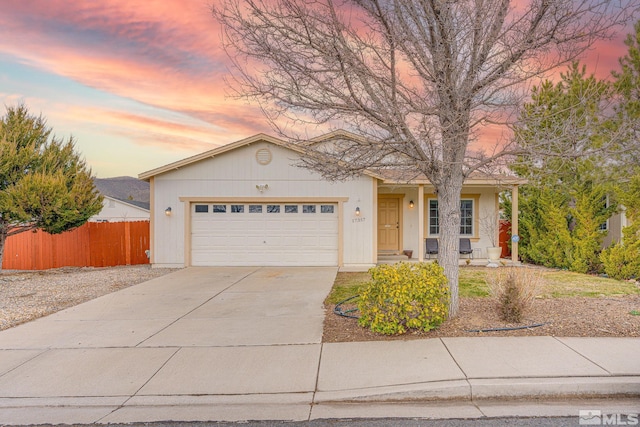 ranch-style home with an attached garage, fence, and driveway