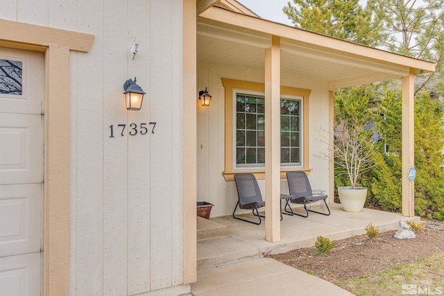 view of exterior entry featuring covered porch