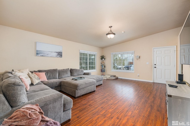 living area with baseboards, lofted ceiling, and dark wood finished floors