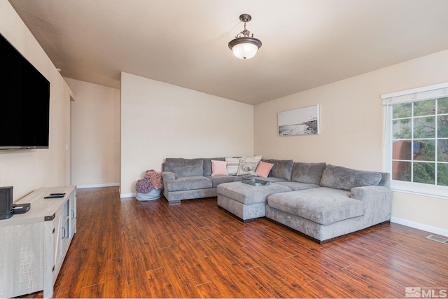 living room featuring wood finished floors, visible vents, and baseboards