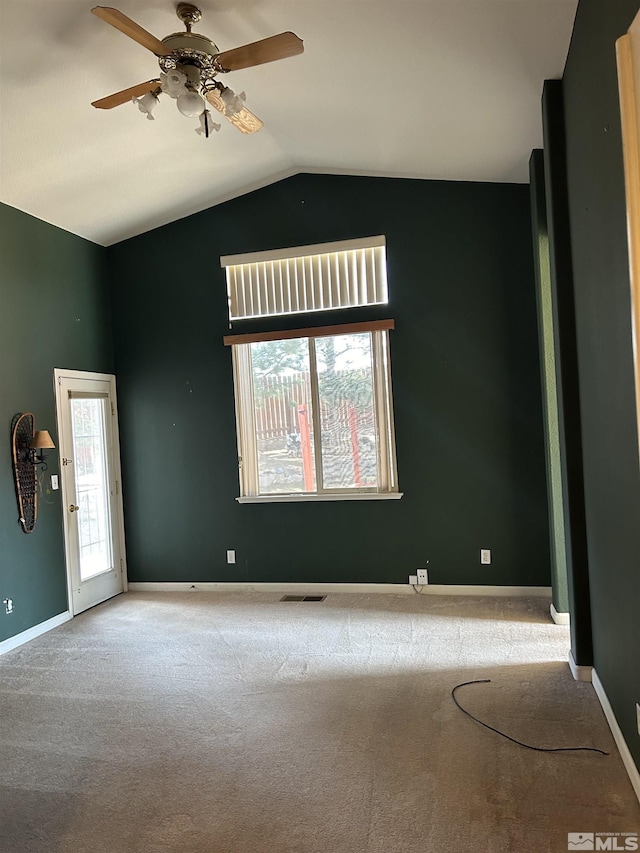 unfurnished room featuring vaulted ceiling, baseboards, carpet floors, and ceiling fan