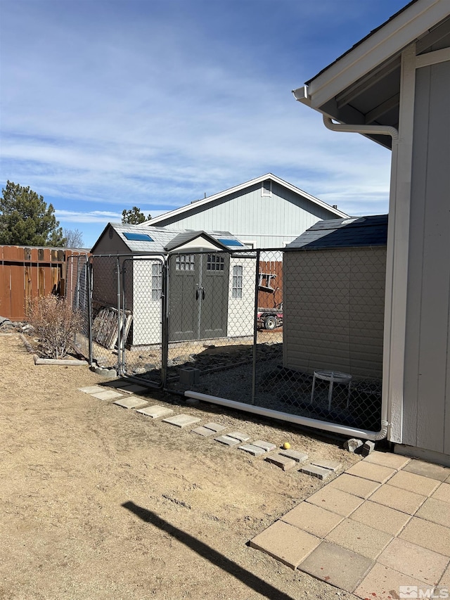 exterior space featuring an outdoor structure, a storage unit, and fence