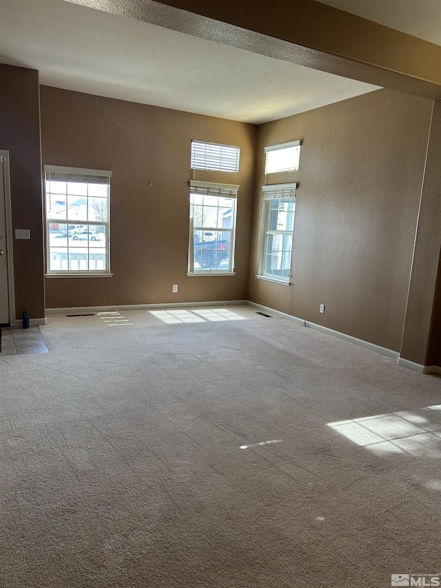 unfurnished room featuring baseboards and light carpet