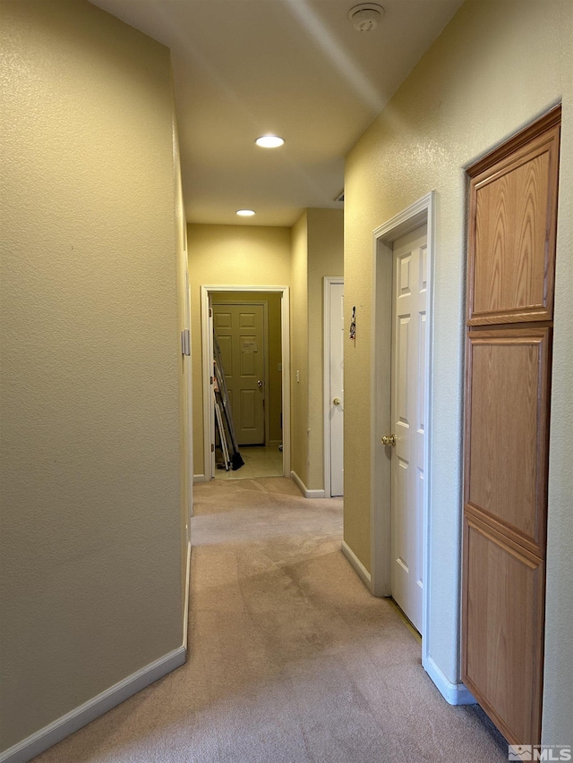 hallway featuring recessed lighting, light colored carpet, and baseboards