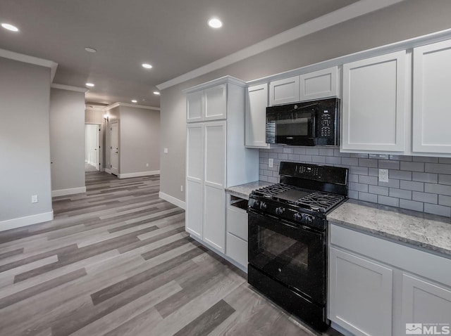 kitchen with backsplash, white cabinets, black appliances, and ornamental molding