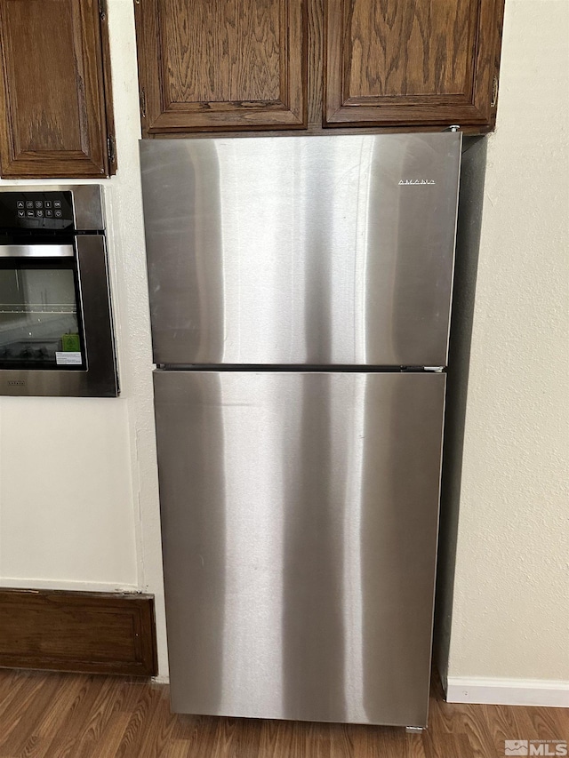 interior details featuring stainless steel appliances, baseboards, and dark brown cabinetry