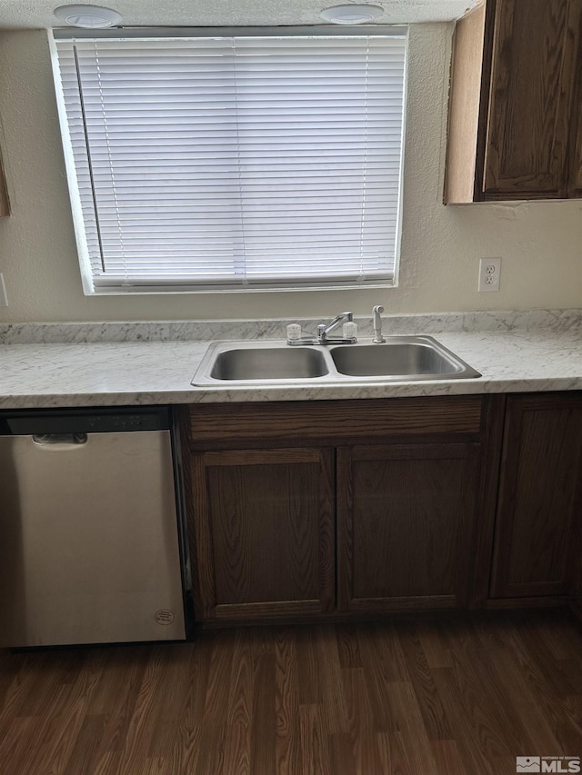 kitchen with a sink, dishwasher, dark wood-style floors, and light countertops