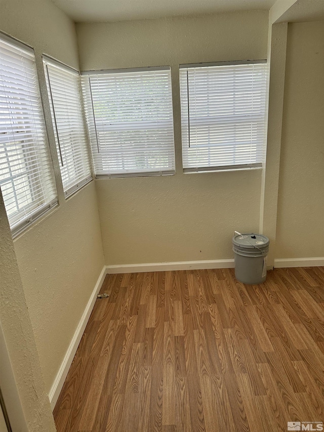 unfurnished room featuring baseboards and wood finished floors