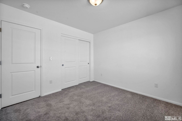 unfurnished bedroom with baseboards, a closet, and carpet floors
